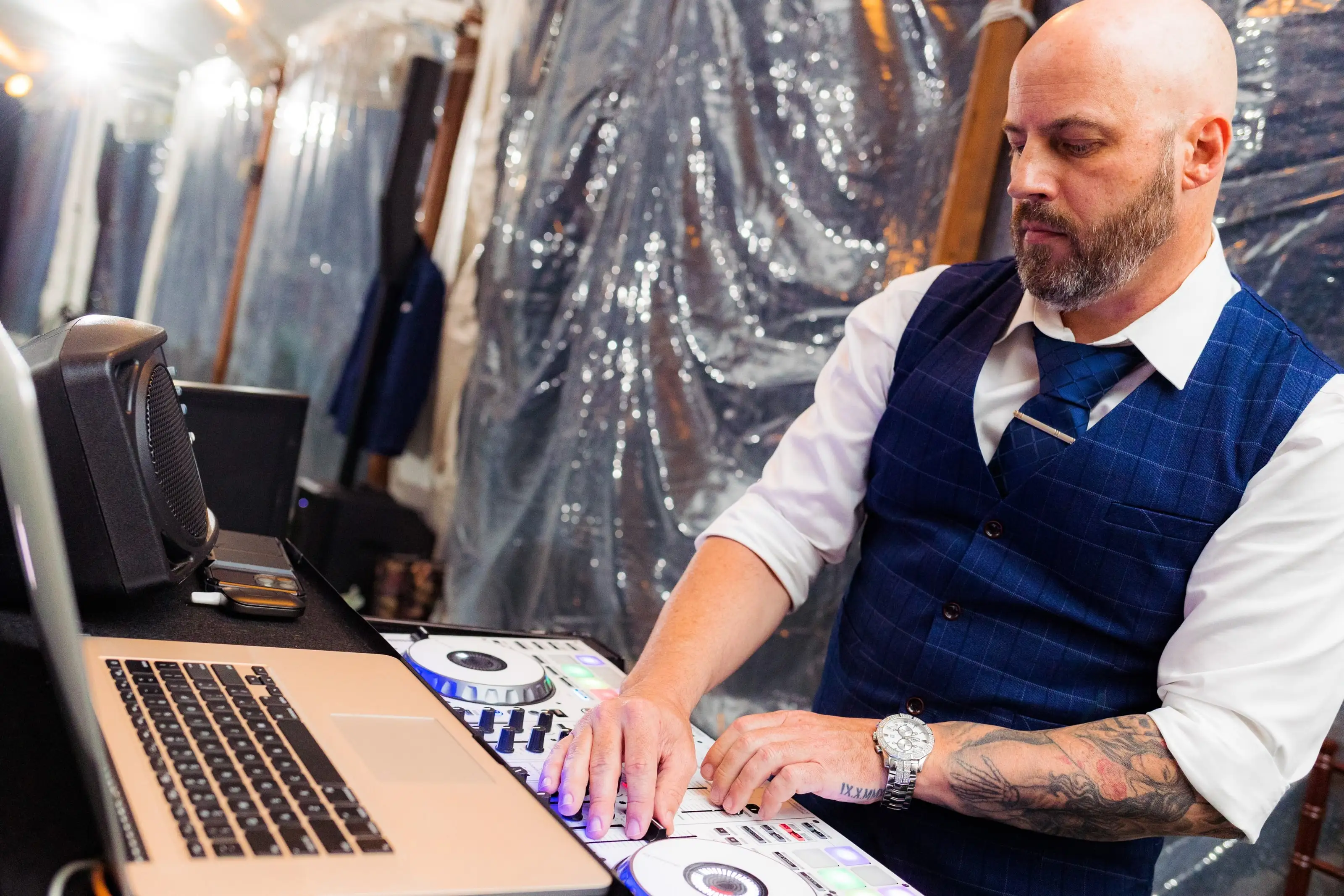 A Maryland's DJ DJ at the decks in front of a sequin backdrop