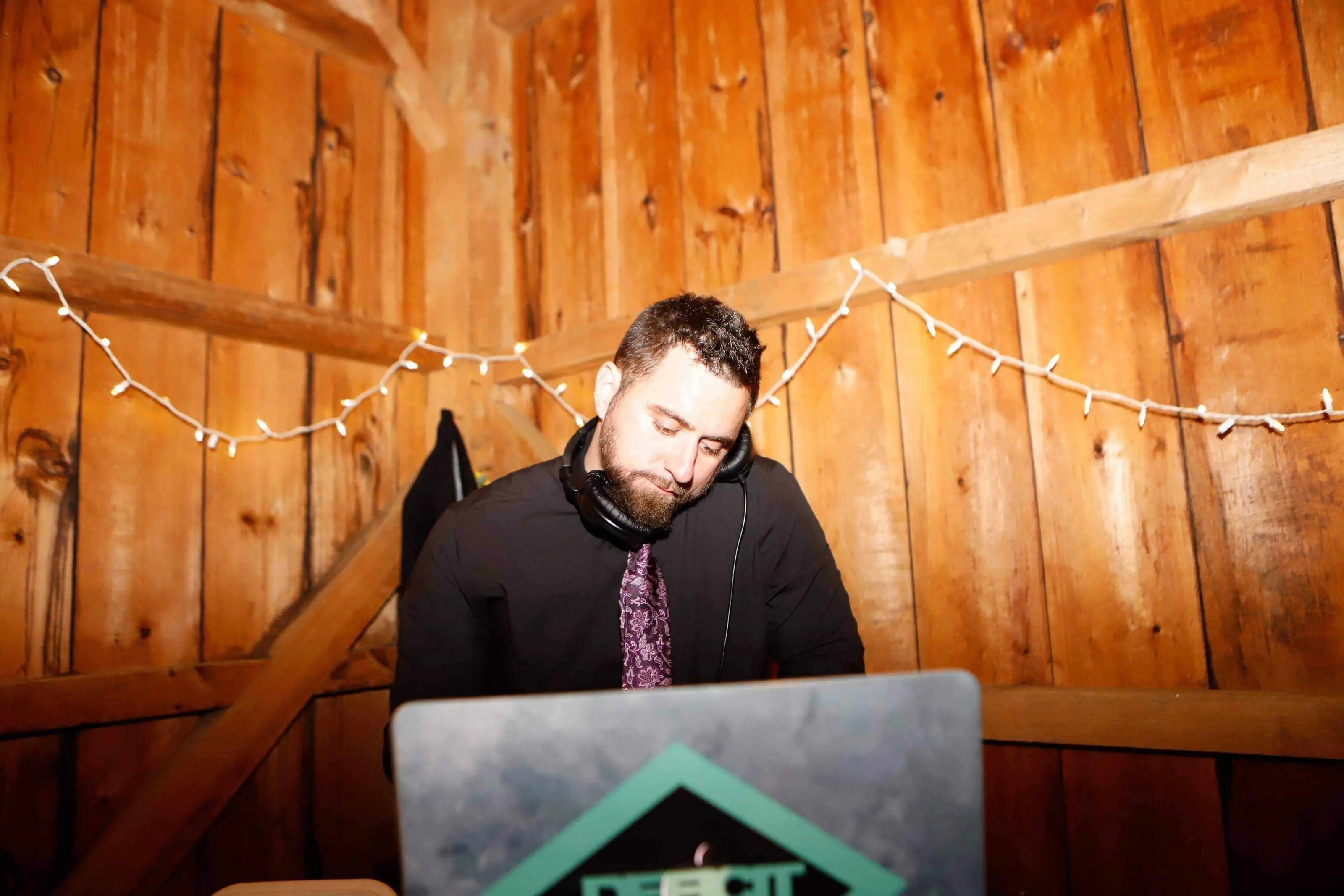 A Maryland's DJ DJ at work in a wooden barn strung with lights
